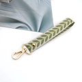 Close-up of beige leaf pattern fabric wrist strap with golden lobster clasp and metal rivet - Gold Buckle / Matcha Green
