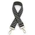Detail of 3.8cm wide adjustable bag strap with black and white woven pattern and gold clips - Black