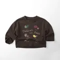 Détail d'un sweat-shirt en coton pour enfants avec illustrations d'aliments et texte - Brun Foncé / 80cm