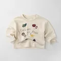 Détail d'un sweat-shirt enfant en coton avec illustrations d'aliments et texte chic - Abricot Beige / 80cm