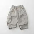 Detailed view of kids cargo pants with elastic waistband and large side flap pockets - Light Gray / 80cm