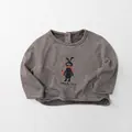 Dettaglio maglietta a righe per bambini con coniglio carino e bottone sul retro - 80cm / Riga Crema