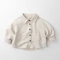 Detalle de chaqueta infantil crema de manga larga con botones negros y cuello de solapa - Beige / 80cm
