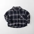 Dettaglio in piano della camicia a quadri per bambini con motivo blu scuro e crema - 80cm / Quadri Navy