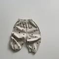 Detail von Elastikbund und schwarzem Punktmuster auf khakifarbenen Kinderhosen - 80cm / Aprikose