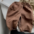 Detailed macro view of girls' loose cotton pants featuring elastic waist and vintage wood button - 80 / Brown