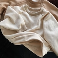 Close-up of children's waffle knit sweatshirts showing textured cotton fabric and ribbed cuffs - Beige