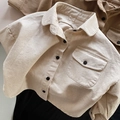 Détail de la texture coton crème avec poche poitrine et boutons noirs contrastants - 80cm / Blanc Cassé