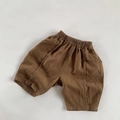 Detail of brown linen cotton shorts for kids showing elastic waist and textured fabric - 80 / Brown