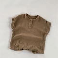 Detail of soft brown muslin cotton infant shirt with a single wood button and round neck - Brown / 80cm