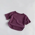 Detailed macro view of the breathable slub cotton texture on dark purple kids' t-shirt - Purple