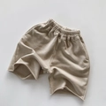Detalle plano de pantalones cortos infantiles de algodón caqui con dobladillo sin rematar - 80cm / Albaricoque