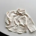 Detailaufnahme der hochwertigen Baumwoll-Leinen-Struktur und Holzknöpfe am Kinderhemd - 80cm / Beige Aprikose