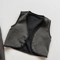 Close-up of kids reversible vest showing grey quilted texture and white polka dot lining - 80cm / Black