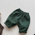 Detailed view of elastic waistband and front pockets on dark green kids casual shorts - Dark Green / 80cm