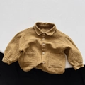 Detailed close-up of textured double gauze cotton fabric and buttons on kids' jacket - 80cm / Yellow