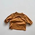 Detailansicht des karamellbraunen Kinder-Poloshirts mit Holzknöpfen und Retro-Kragen - 80cm / Gelb