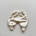 Detalle de pantalones deportivos infantiles con cintura elástica y puños de canalé suaves - 120cm / Albaricoque