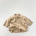 Vista piatta di una camicia di cotone kaki a vestibilità ampia con doppie tasche sul petto - 80cm / Cachi