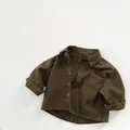 Dettaglio camicia per bambini verde oliva in cotone con bottoni e taschino - Marrone / 80cm