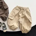 Detail of kids cargo pants showing durable cotton fabric and large side utility pockets - Khaki / 80cm