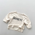 Close-up of the MOMENT letter print and soft cotton texture on beige kids long sleeve tee - 80cm / Beige