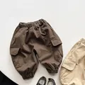 Detail view of cargo pants with elastic waist and flap pockets in brown and khaki - Dark Coffee / 80cm