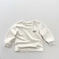 Detail of soft linen cotton fabric and Happy Day print on the long sleeve kids T-shirt - 80cm / Beige Apricot