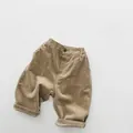 Detail of khaki corduroy texture on children's loose pants with elastic waist and button - 80cm / Khaki