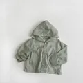 Detail view of light green hooded sun protection jacket with four buttons and round pockets - Mint Green / 80cm