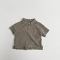 Close-up of kids cotton polo shirt showing fabric texture, buttons and side slit detail - 80cm / Brown Grey