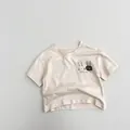 Detail eines Baumwoll-Kinder-T-Shirts mit Hasen-Stickerei und One Two Three Schriftzug - 80cm / Beige Aprikose