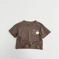 Detail eines weichen Kinder-T-Shirts aus Baumwolle in Dunkelbraun mit Hasen-Print - 80cm / Braun