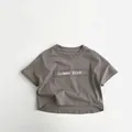 Detailansicht eines Baumwoll-Kinder-T-Shirts mit Gummy Bear Patch und Fransen - 80cm / Grau