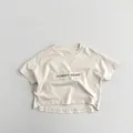 Nahaufnahme von Gummy Bear Patch und weichem Baumwollstoff auf cremefarbenem Kinder-T-Shirt - 80cm / Aprikose