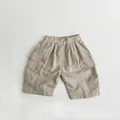 Detail view of khaki cotton linen cargo shorts with elastic waist and large flap pockets - 80cm / Beige