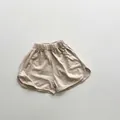 Detailed shot of oat beige cotton shorts featuring elastic waist and dolphin hem design - Light Khaki