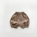 Detalle de la textura de gasa de algodón suave en el pantalón bombacho para bebé - 80cm / Caqui