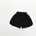 Detail view of children's black cotton shorts featuring elastic waist and curved hems - Black / 80cm