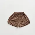 Detail view of brown cotton kids shorts with breathable slub texture and elastic waist - Brown