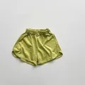 Detailed view of grass green cotton shorts featuring elastic waist and dolphin-cut hem - Fruit Green / 80cm