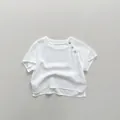 Detail of white cotton linen kids t-shirt showing shoulder buttons and fabric texture - 80cm / Off-white