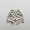 Detailed close-up of kids beige knit shorts with elastic waistband and utility pocket - Apricot / 80cm
