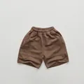 Detail of children's brown cotton knit shorts featuring elastic waist and side pocket - Brown / 80cm