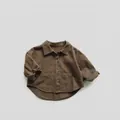 Detail of dark brown kids corduroy shirt with buttons and large pockets in minimalist style - 80cm / Brown
