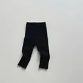 Detail of children's black ribbed leggings featuring a wide elastic comfort waistband - 80 / Black