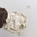 Dettaglio di magliette a maniche lunghe in cotone per bambini con polsini arrotolati - 80cm / Albicocca