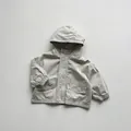 Close-up of beige hooded jacket featuring large cargo pockets and elastic cuffs - 80cm / Grey-Beige