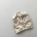 Detailaufnahme der beigen gesteppten Kinderweste mit Reißverschluss und vier Fronttaschen - 80cm / Khaki
