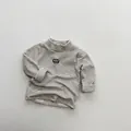 Détail d'un sous-pull rayé à col roulé pour enfant doublé en polaire avec logo rond - 80cm / Rayé Beige Marron